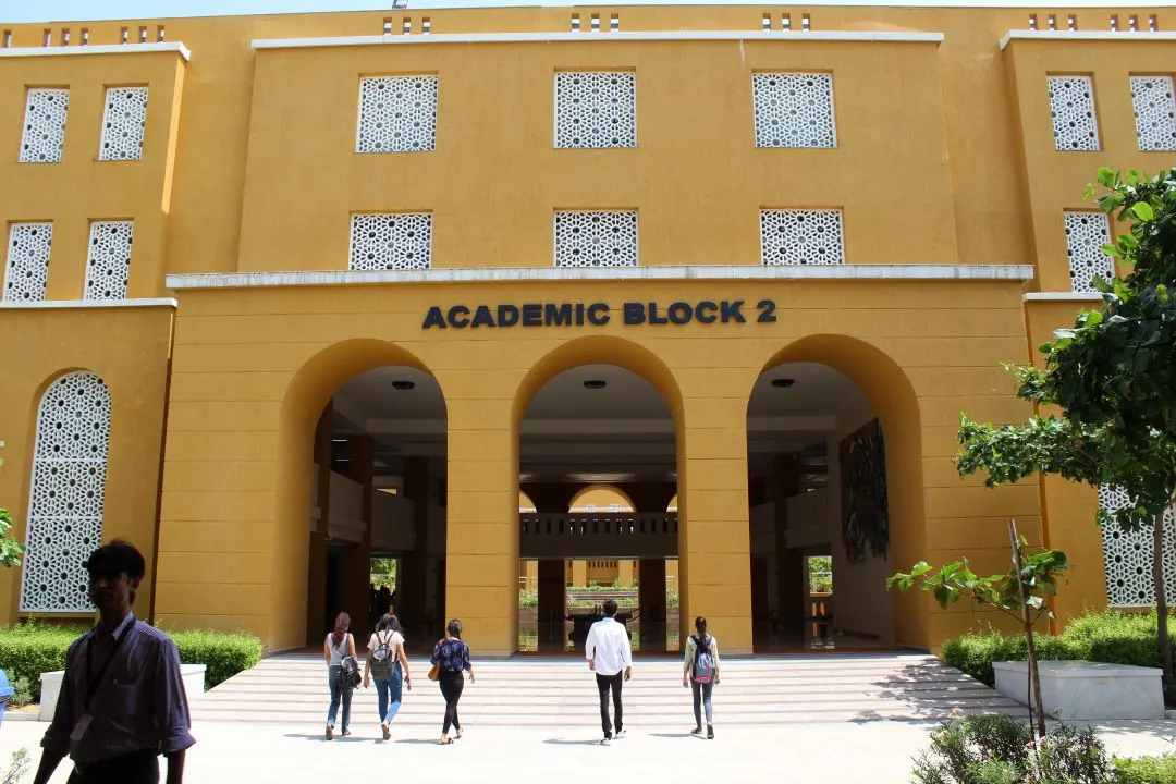 Students walking into the arched entrance of Academic Block 2, MUJ